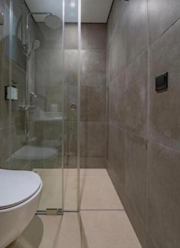 ein Badezimmer mit Glasdusche und Toilette in der Unterkunft Cross Suites in Tema