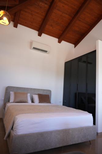 a bedroom with a large bed and a wooden ceiling at Pinat HaNahal in HaGoshrim