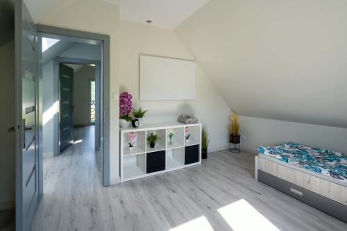 a bedroom with a bed and a white wall at Domek pod Nowiną in Tylmanowa