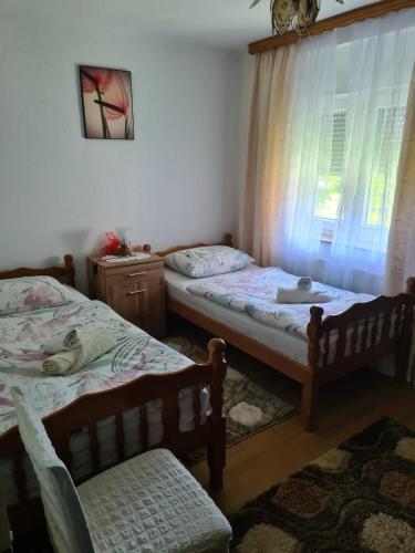 two twin beds in a room with a window at Apartment Dolic - Your peaceful spot with a panoramic view in Livno
