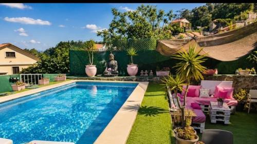 a swimming pool in a yard with potted plants at O refuxio do mar in Oia