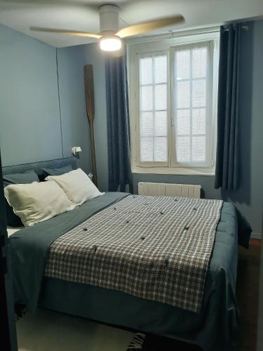 a bedroom with a bed and a ceiling fan at La Cabane du Pecheur in Honfleur