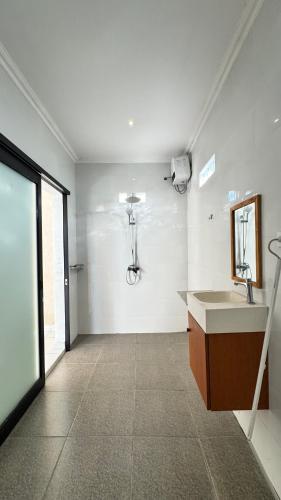 a bathroom with a sink and a mirror on the wall at Vila Billy II in Munggu