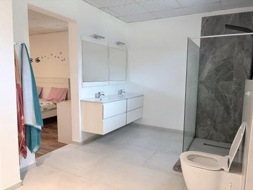 a bathroom with a shower and a toilet and a sink at Mais Residence in Bijilo