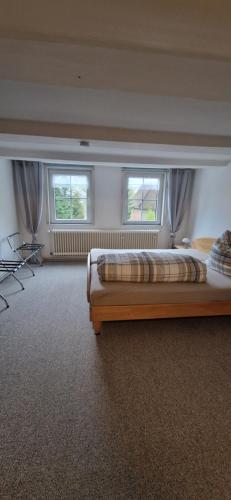 a bedroom with two beds and two windows at Dehmkerhof in Aerzen