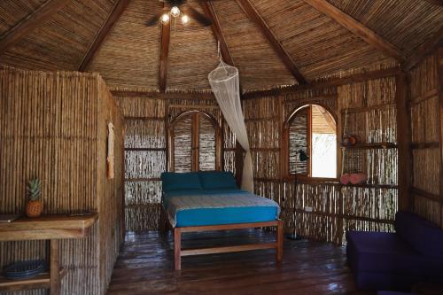 a room with a bed in a straw hut at Adama Eco Farm in Santa Catalina
