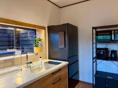 a kitchen with a sink and a refrigerator at 鴨川ビーチハウス in Kamogawa