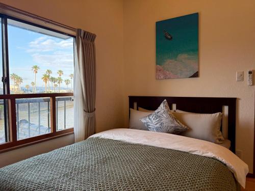 a bedroom with a bed with a view of the ocean at 鴨川ビーチハウス in Kamogawa