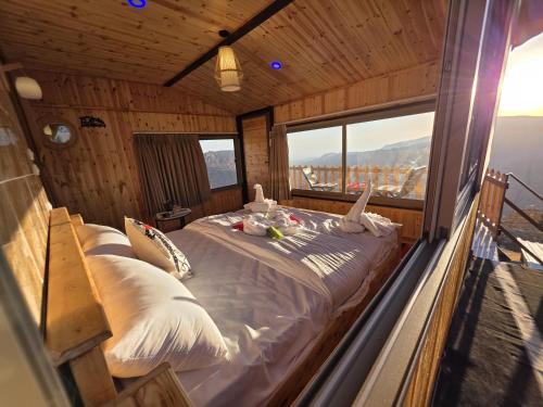 ein Bett in einem Zimmer mit einem großen Fenster in der Unterkunft Dana Tower Hotel in Dana