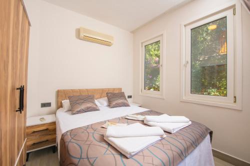 a bedroom with two beds and two windows at Marvera Hotel in Fethiye