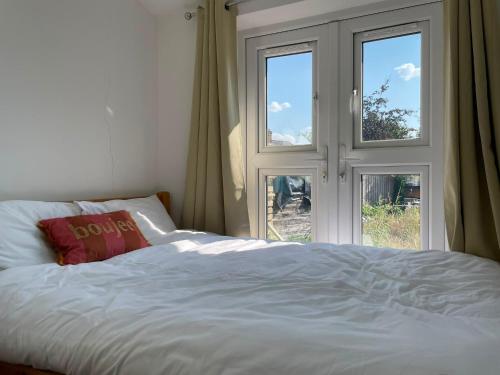 a bed with a pillow on it next to a window at Oxford Luxury Flat in Oxford