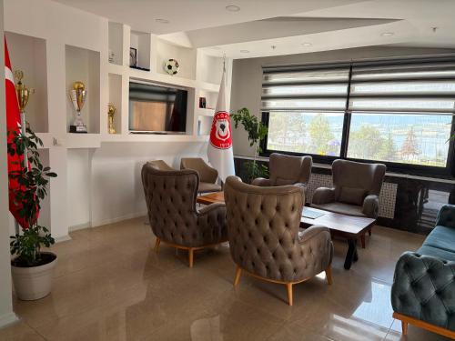 a living room with chairs and a table and a christmas stocking at Gölpark Otel in Yeniçağa