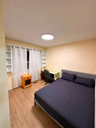 a bedroom with a bed and a desk with a computer at Treverton Retreat in Toronto