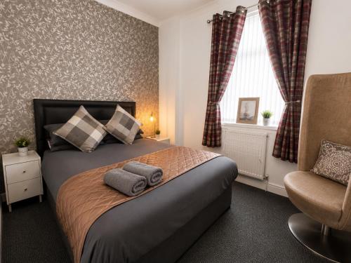 a bedroom with a bed with two towels on it at Hillhead Apartment in Coylton