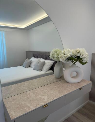 a bedroom with a bed with flowers on a table at Apartment Dolce by DuBooker in Trpanj