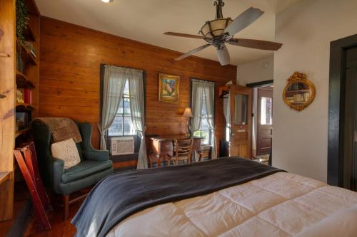 a bedroom with a bed and a chair and a table at Downtown Chantilly Ste Piedmont in Eureka Springs