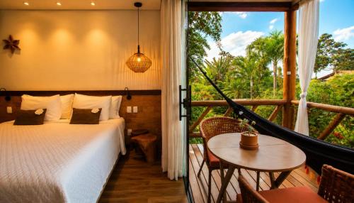 a bedroom with a bed and a balcony with a window at Pousada Meu Talento in Alto Paraíso de Goiás