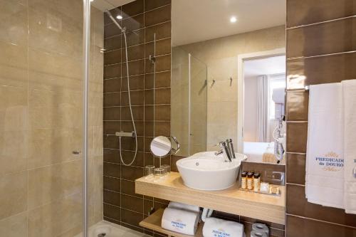 a bathroom with a sink and a shower at Predicados do Douro Palace in Porto