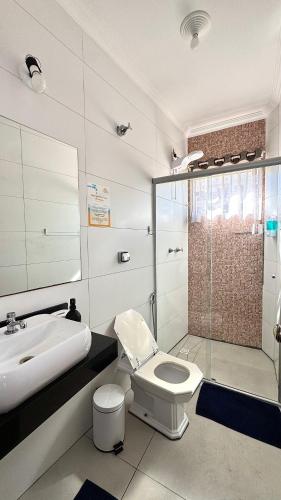 a bathroom with a toilet and a sink and a shower at Hotel Vila Solar in Limeira