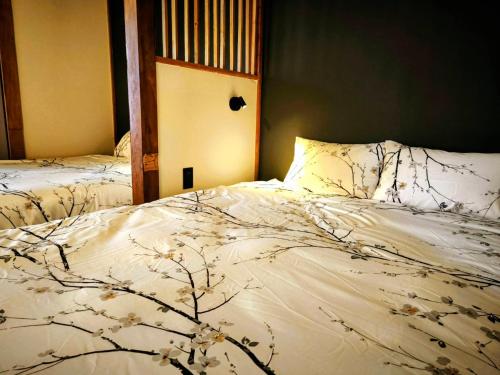 a bedroom with two beds with white comforter at Prirate Villa Naru in Shiraoi