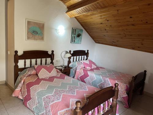 a bedroom with a bed and a wooden ceiling at Casa Campaner in Valencia de Aneu
