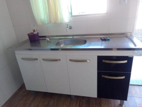 a bathroom counter with a sink and a window at Pousada Paraíso in Telêmaco Borba