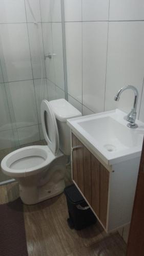 a bathroom with a toilet and a sink at Pousada Paraíso in Telêmaco Borba