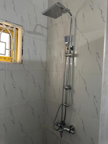 a shower with a shower head in a bathroom at Rashlie apartment in Freetown