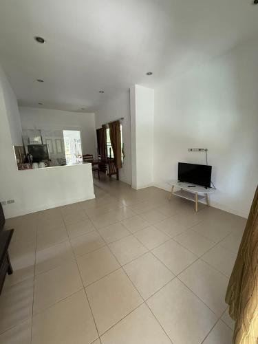 a living room with a tv and a tiled floor at olivia village pool resort in Mae Nam