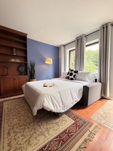 a bedroom with a large bed and a couch at Maison Des Jardins B & B in Montreal