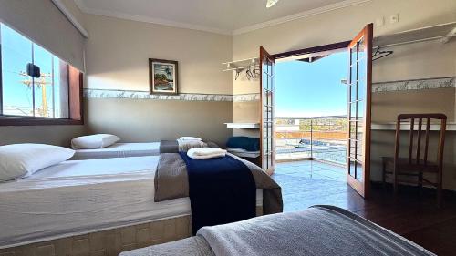 a bedroom with two beds and a sliding glass door at Hotel Vila Solar in Limeira