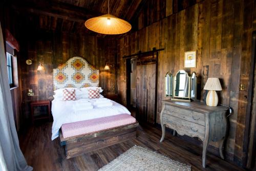 a bedroom with a bed and a dresser with a mirror at Iris - The Nook Lodges in Nantwich