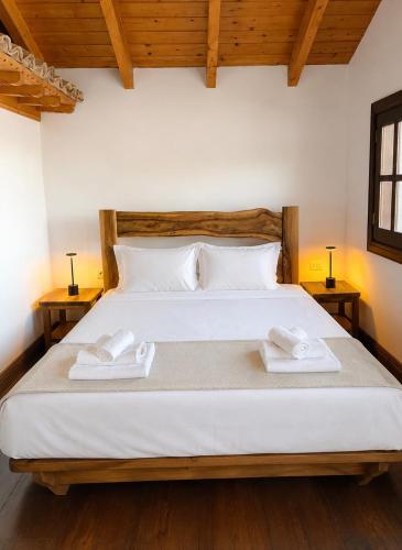 a bedroom with a bed with two towels on it at Villa Monte Shpirag in Berat
