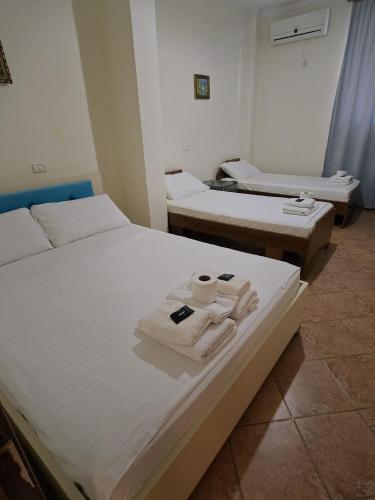 two beds in a room with towels on them at Onde Rooms in Vlorë