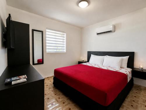 a bedroom with a large bed with a red blanket at Ladybugs Apartments in Palm-Eagle Beach