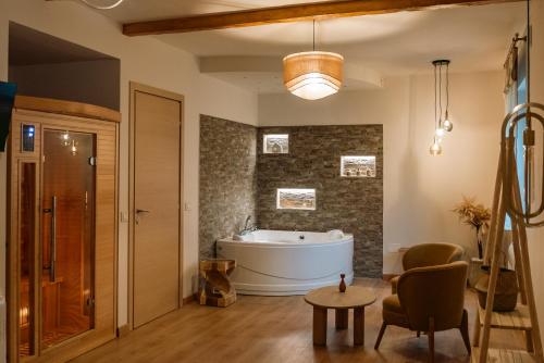 a bathroom with a tub and a chair and a table at Chiarelli Mountain Suite in Camigliatello Silano