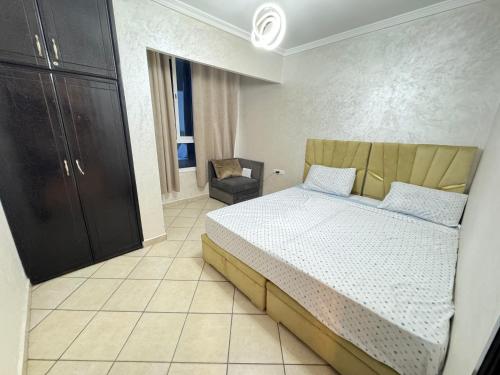 a bedroom with a bed and a chair in it at Cozy Ajanif Suite in Martil