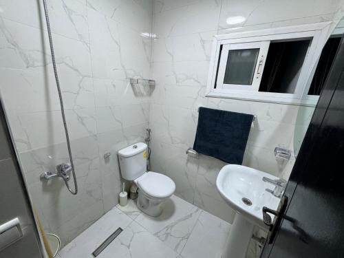 a white bathroom with a toilet and a sink at Cozy Ajanif Suite in Martil