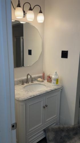 a bathroom with a sink and a mirror at A J House in Plano