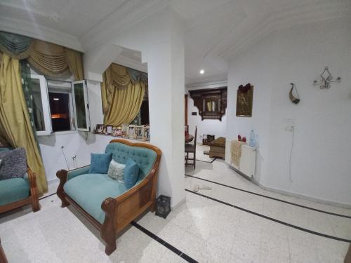 a living room with a blue couch in a room at Nour 2 in Le Bardo