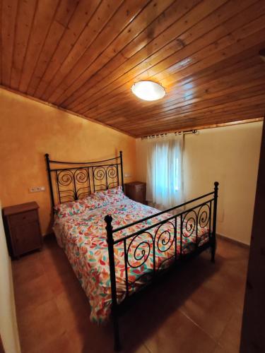 a bedroom with a bed with a wooden ceiling at La Casa Azul Bullas in Bullas