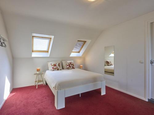 a white bedroom with a bed and a mirror at Laurahoeve in Nederweert