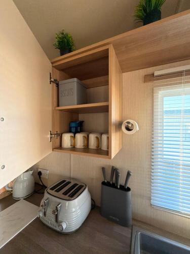 a kitchen with a toaster on a counter next to a window at The Casa Descanso in Rhyl