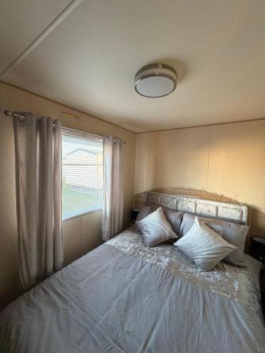 a bed in a small room with a window at The Casa Descanso in Rhyl