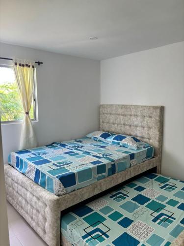 a bedroom with a bed and a window at Aparta Hotel Casacrislaye Santa marta in Santa Marta