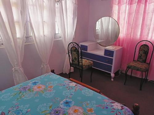 a bedroom with a bed and a dresser and a mirror at Gazebo in Port-of-Spain