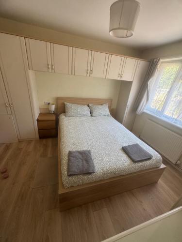a bedroom with a bed with two pillows and a window at Joni Bungalow-2-Bedroom HOME in Slades Green