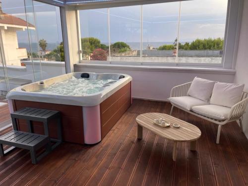 a bath tub in a room with a couch and a table at Almaré Luxury Beach Apartments in Taranto