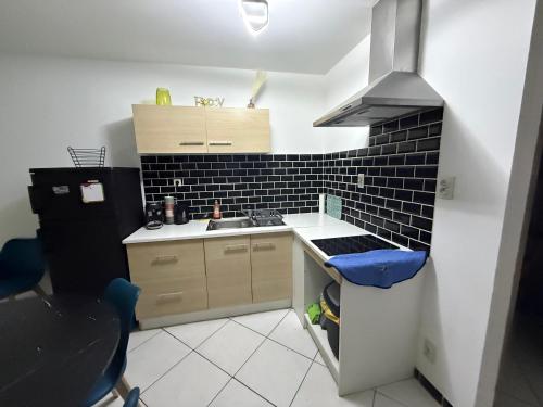 a small kitchen with a sink and a stove at Petit nid chaleureux in Mimizan