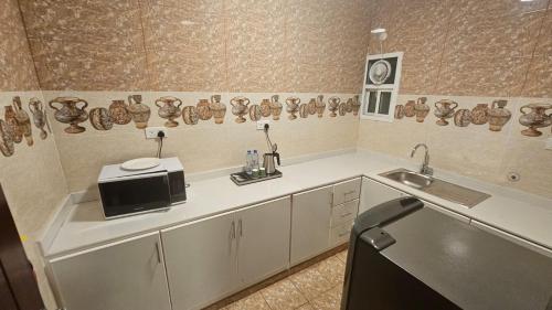 a kitchen with a sink and a microwave at SR Hotel in Salalah